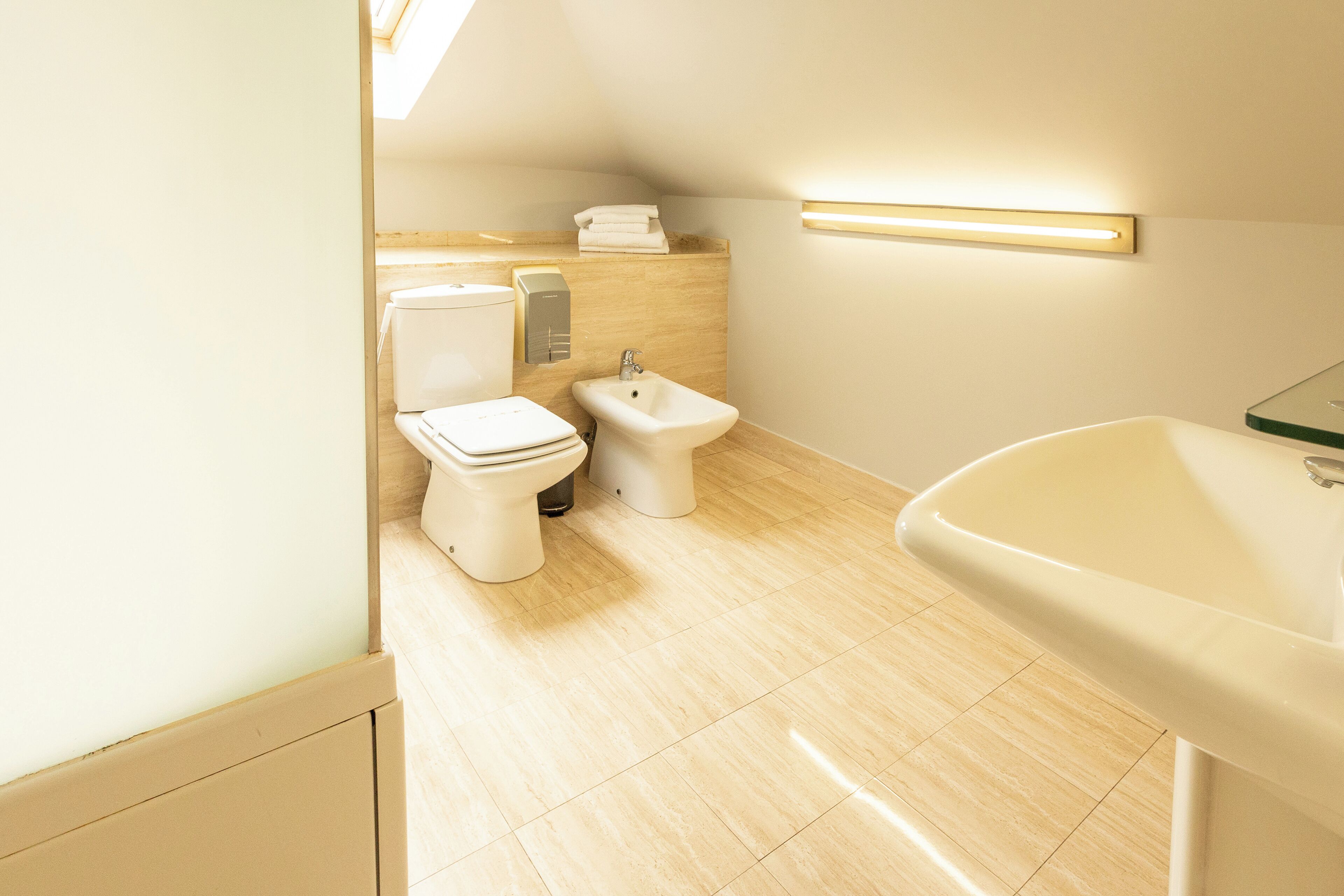 A modern bathroom with a toilet, bidet, and sink.