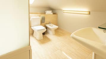 A modern bathroom with a toilet, bidet, and sink.