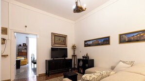 A living room with a sofa, a television, a bookshelf, and framed pictures on the wall. - Get the local feel in a nice and safe neighborhood in the heart of Rome! (rome)