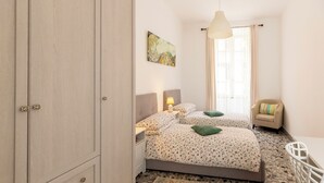 A bedroom with a bed, bedside tables, a chair, a desk, and a large wardrobe. - Get the local feel in a nice and safe neighborhood in the heart of Rome! (rome)