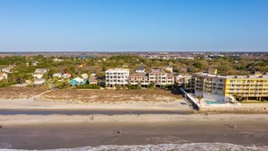 Un hotel costero con varias construcciones, una playa y vista al océano.