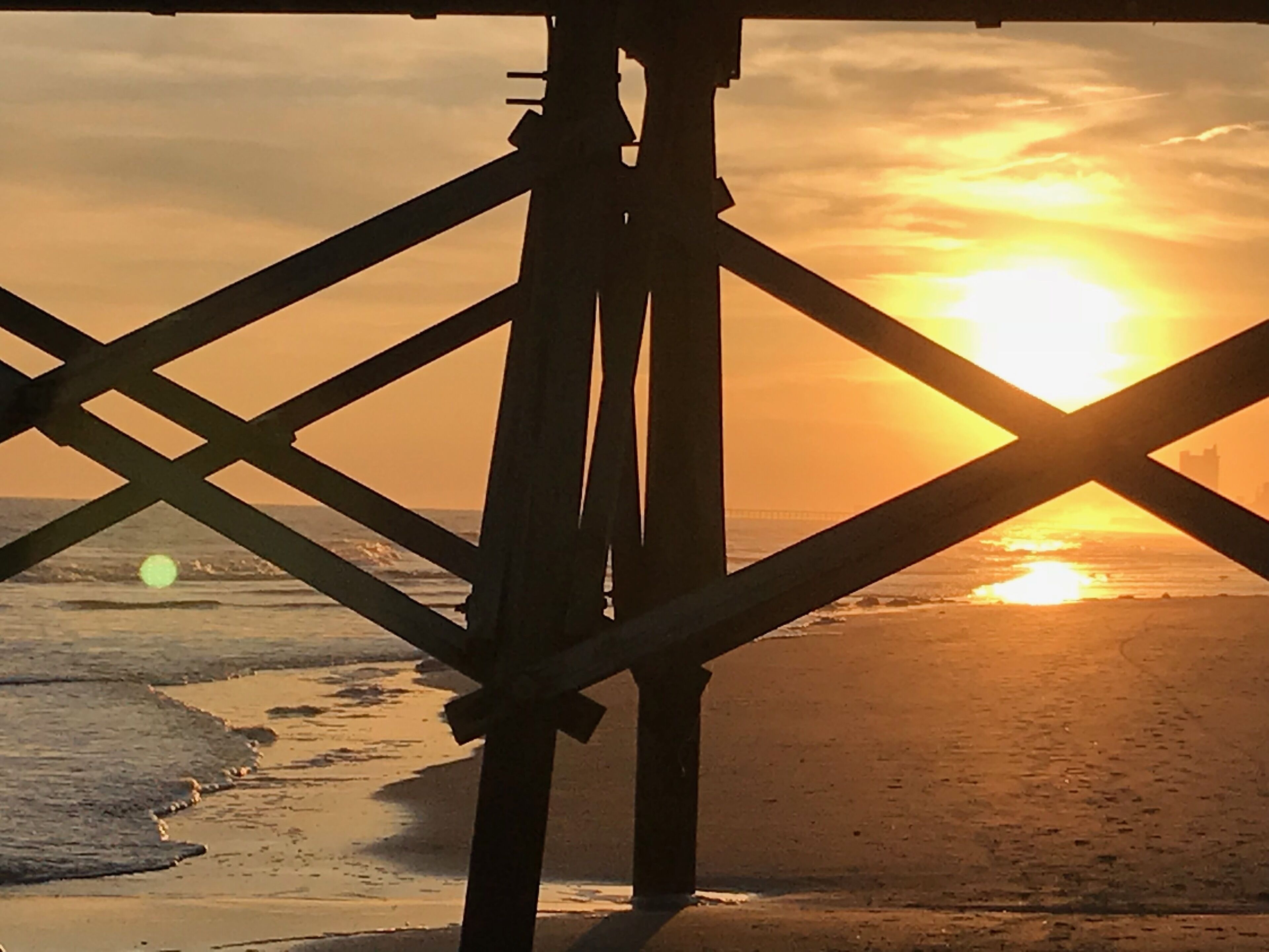 Eine Stegkonstruktion mit Blick auf den Sonnenuntergang über dem Meer.