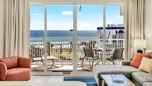 Ein geräumiges Zimmer mit einer großen Schiebetür und einem Balkon mit Blick auf Strand und Meer.