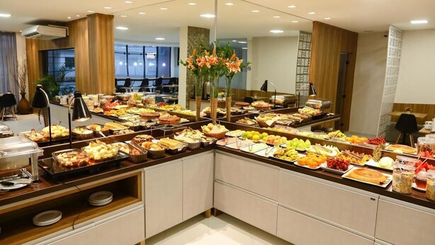 Un bufé con diferentes opciones de comida y un espejo que refleja la sala.