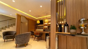 Un interior moderno con un mostrador de recepción de madera, una zona de estar y una escalera.