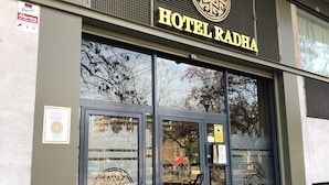 L’entrée de l’hôtel Radha, avec un logo et une enseigne bien visibles.