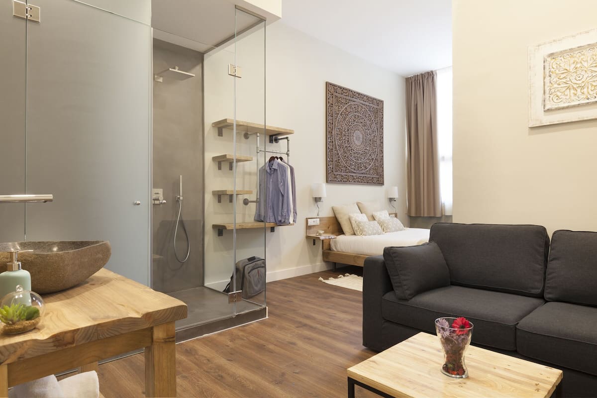 Una sala de estar moderna con sofá, una mesa de centro y un box de ducha de vidrio.