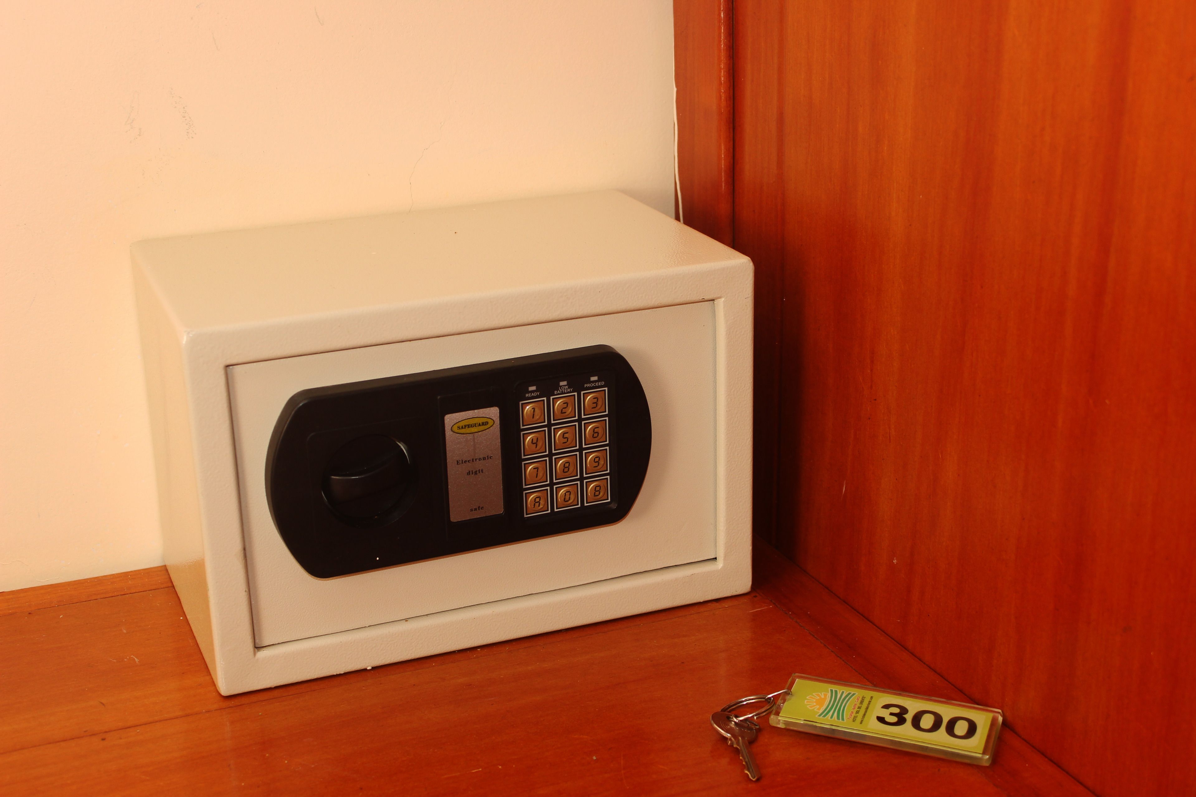 Una caja fuerte blanca con cerradura de teclado y un llavero.