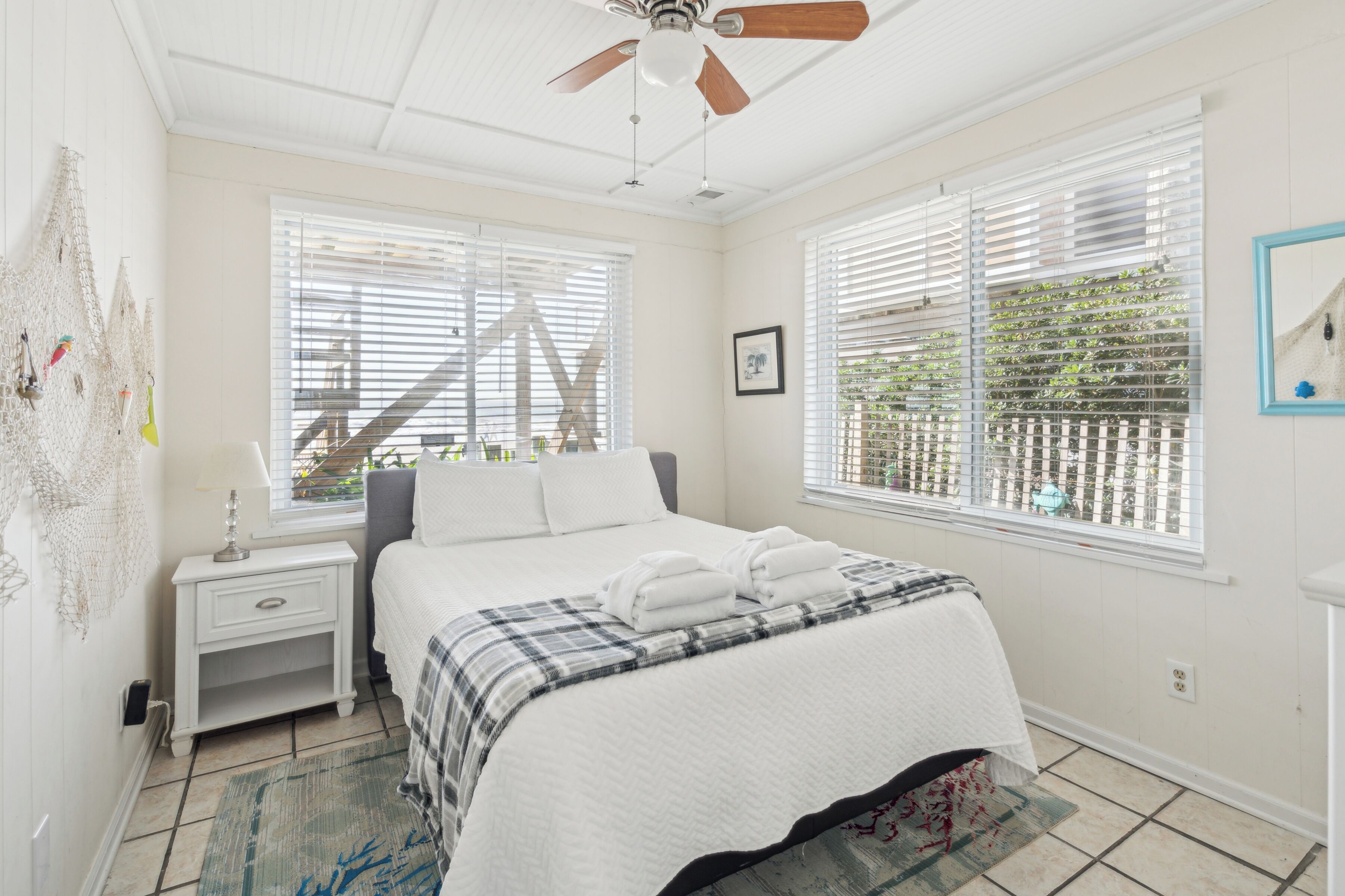 A bedroom with a bed, nightstand, and a ceiling fan.