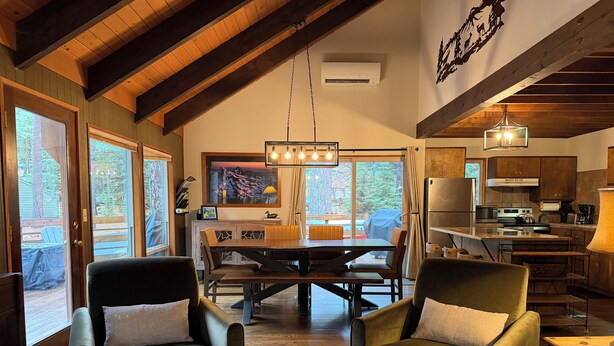 A spacious living room with a wooden ceiling, a dining area with a large table, and a kitchen with modern appliances. - Basecamp for endless adventure, perfect Black Butte location - Hot Tub! (Sisters)