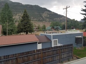 Zona residencial con casas, cerca de madera y montañas al fondo.