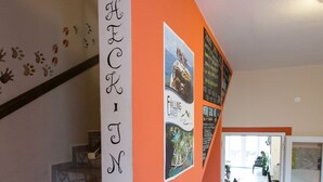 A staircase with a handrail, a wall with directional arrows, and a poster. - Falling Lakes Hostel (Plitvicka Jezera)