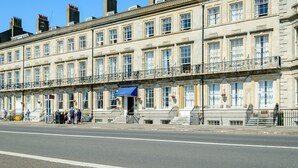 A row of traditional buildings with multiple windows and a blue awning. - Russell Hotel (Weymouth)