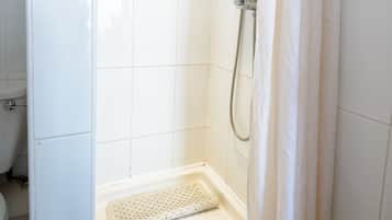 Ducha con cortina blanca, cabezal de ducha de mano y desagüe en el suelo.