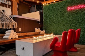 A modern outdoor seating area with a fire feature, a neon sign, and a green wall. - Unique , contemporary with HOT TUB!!! (Denver)