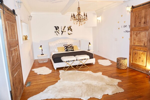 Ein Schlafzimmer mit Bett, einer Kandelaber und einem großen Fellteppich.