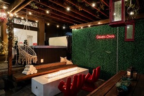 A cozy lounge area with a fire feature, seating, and a neon sign reading 'Denver Oasis.' - Unique , contemporary with HOT TUB!!! (Denver)