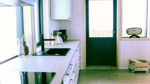 A kitchen with a sink, cabinets, and a window.