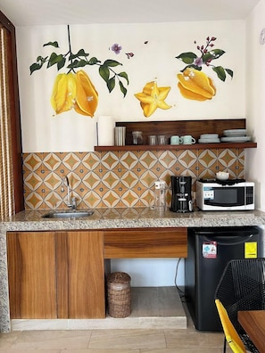 A kitchen with a sink, microwave, and coffee maker.