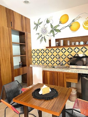 A compact kitchen with wooden cabinets, a microwave, and a sink.