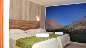 Ein Hotelzimmer mit zwei Betten, einem Wandbild von einer Berglandschaft und einer Wandleuchte.