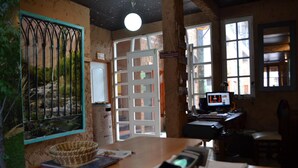 Ein Zimmer mit einem Holztisch, einem Computer, einem Telefon und einem Fenster mit Blick auf eine felsige Landschaft.