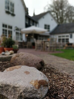 A stone pathway leading to a building with a white facade and multiple windows. - De Kastanjehof (Lage Vuursche)
