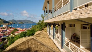 Ein Küstenhotel mit Balkon und Blick auf einen Yachthafen und das Meer.