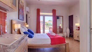 Ein Hotelzimmer mit Bett, Badezimmer mit Waschbecken, Dusche und Blick nach außen.