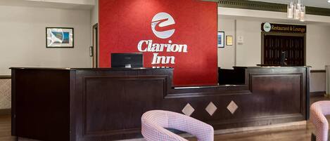 Mostrador de recepción en Clarion Inn con logotipo rojo, una computadora y mostradores de registro.