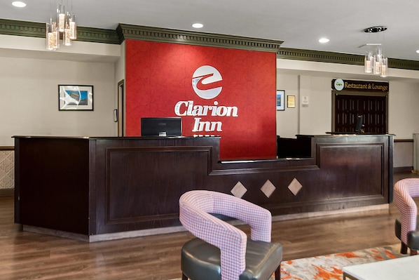 Mostrador de recepción en Clarion Inn con logotipo rojo, una computadora y mostradores de registro.