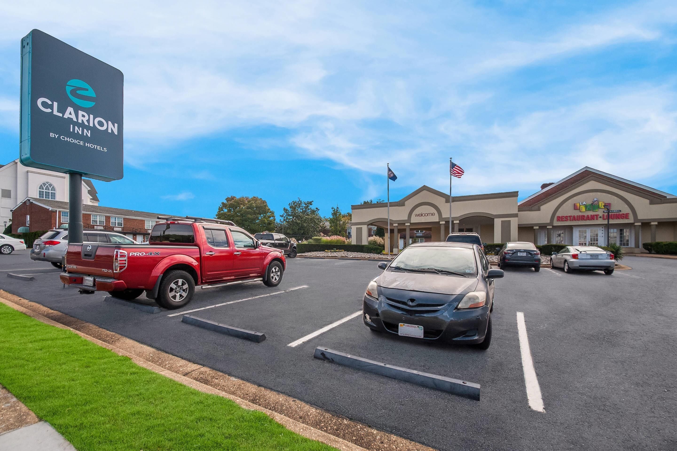 A parking lot with a sign for Clarion Inn by Choice Hotels.