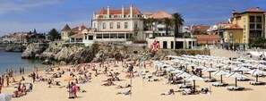 Una spiaggia con molti ombrelloni e persone che prendono il sole.