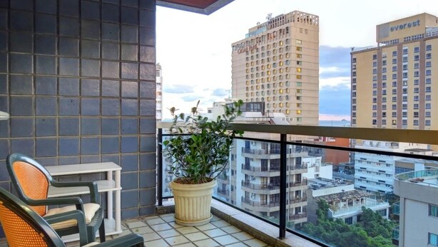 Un balcone con una sedia, un tavolino e una pianta in vaso.