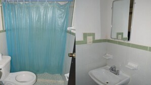 Een badkamer met toilet, wastafel en douchegordijn.