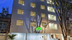 A modern hotel with a flat facade, multiple windows, and a well-lit entrance. - Torca Hotel (Cali)