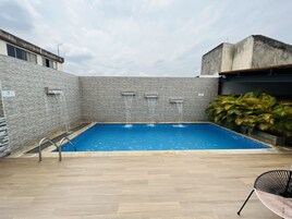 Una piscina al aire libre, sillones reclinables de piscina