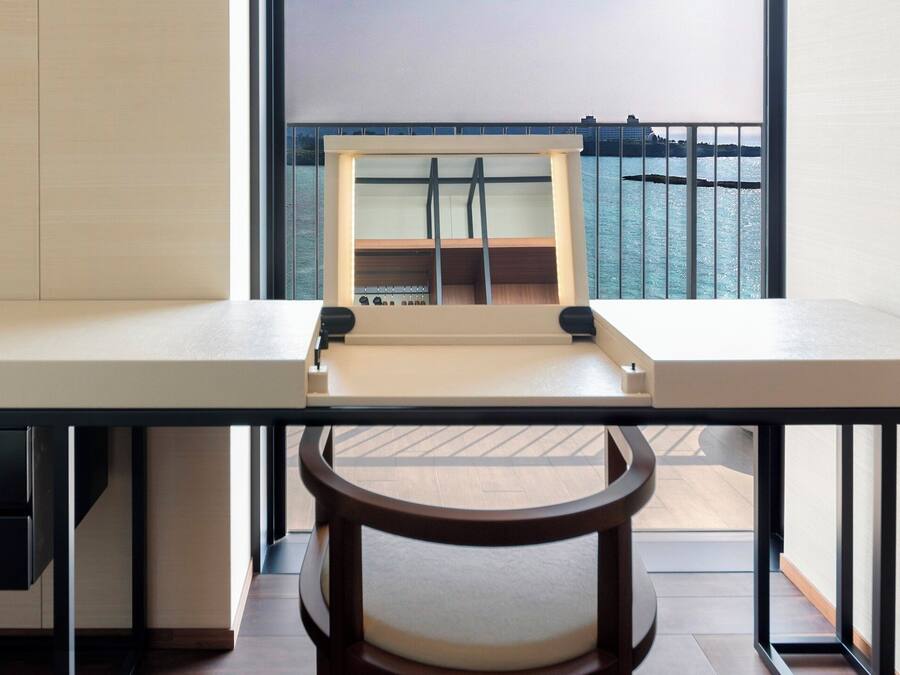 A modern room with a desk, a chair, and a view of a cityscape through a window.