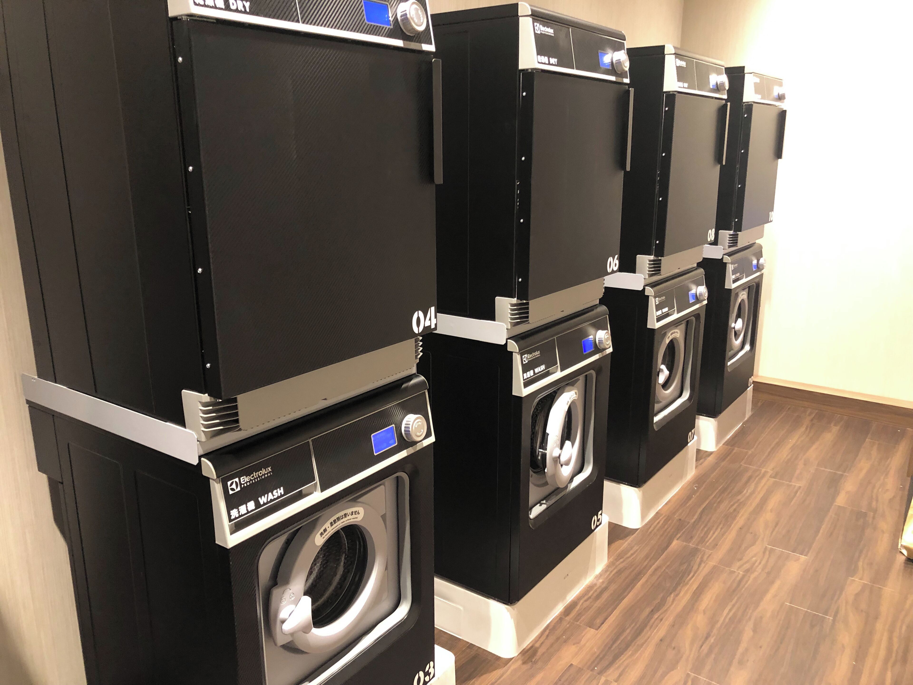 A row of Electrolux front-loading washing machines in a showroom.