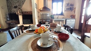 A dining area with a table set for two, featuring a fruit bowl, cups, and a knife. - Characteristic tuscan rustic (Camaiore)