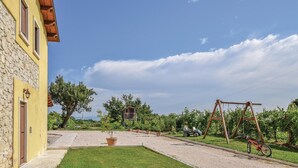 A courtyard with a stone building, a swing set, and a gravel path. - Beautiful apartment in Longare -VI- with WiFi (Longare -VI-)