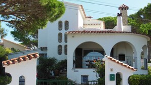 A white building with arched windows and a stone chimney, featuring a gated entrance and a small balcony. - Villa in L'Escala, Costa Brava, Spain. - Private Pool (L'Escala)