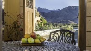 A table with a fruit bowl, a chair, and a view of mountains and a lake. - AV149-Loreto Bay-Luxury Private Villa with Pool (Loreto)