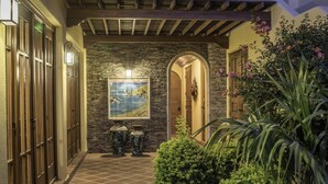 A hallway with a stone wall, a painting of ducks, and a door leading to a room. - AV149-Loreto Bay-Luxury Private Villa with Pool (Loreto)