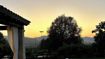 Een buitenzwembad, ligstoelen bij het zwembad