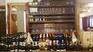 A bar area with shelves of wine bottles and glasses. - Hotel Martin (Sauze d'Oulx)