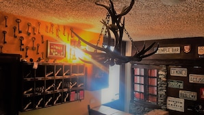 A room with a wall-mounted key rack, a mounted deer head, and various license plates. - Hotel Martin (Sauze d'Oulx)