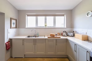 Kjøleskap, mikrobølgeovn, oppvaskmaskin og høy barnestol