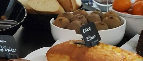 A buffet with various baked goods including bread, cakes, and pastries.