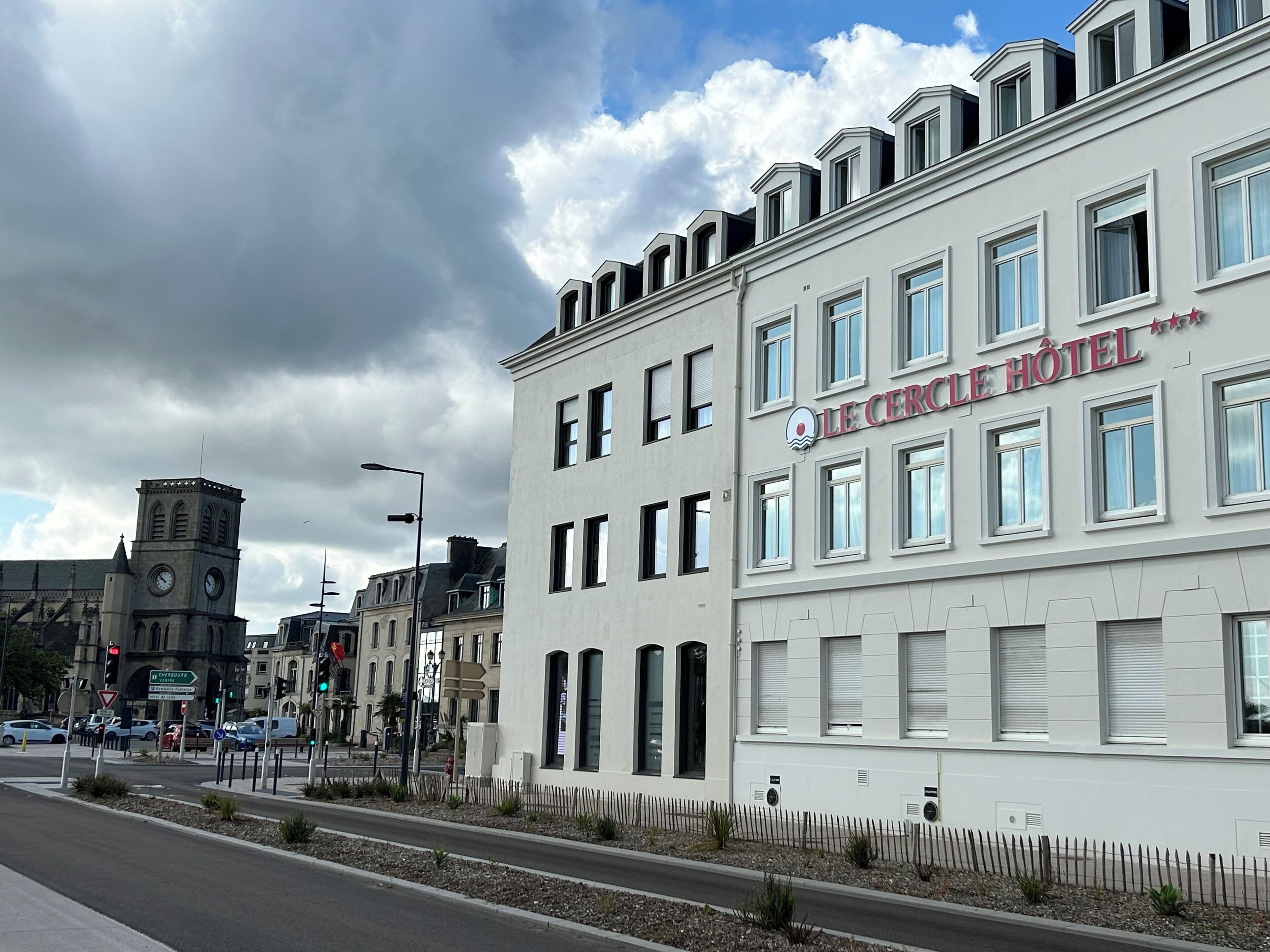 A hotel with a modern facade, multiple windows, and a sign reading "Le Cercle Hotel".